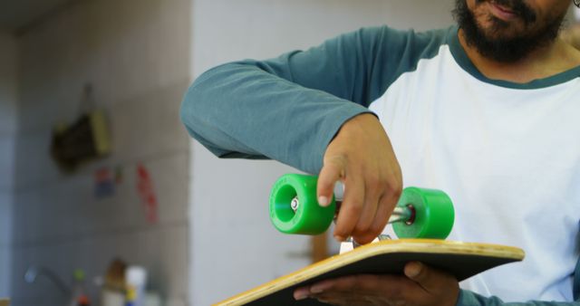 Close-Up of Skateboard Maintenance by Bearded Man in Casual Shirt - Download Free Stock Images Pikwizard.com