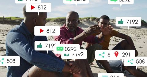 Senior man discussing with younger men on beach with social media notification overlays