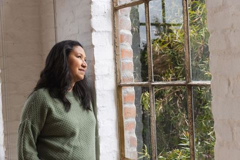Woman Reflecting By Rustic Window with Garden View