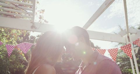 Young Couple Embracing under Sunny Sky with Bunting