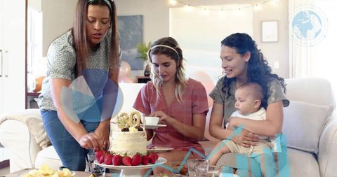 Women celebrating 30th birthday cutting cake with friends and baby in cozy living room