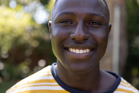 Radiant African American Man Smiling in Sunlit Backyard Garden Portrait of Warmth and Joy
