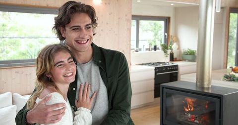 Couple Embracing in Warm Modern Living Room with Wood-Burning Stove