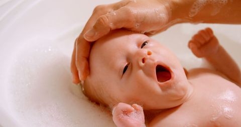 Caregiver Bathing Infant with Gentle Touch in Cozy Bathroom