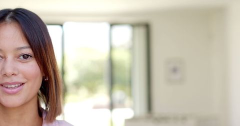 Smiling Young Biracial Woman at Home in Soft Daylight Environment