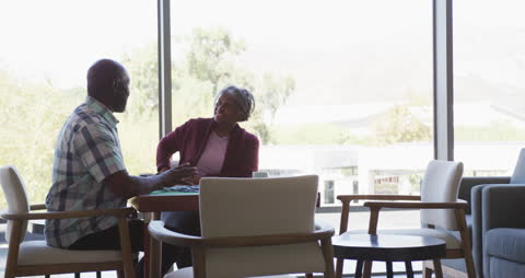Senior Couple Engaging in Conversation at a Bright Cafe