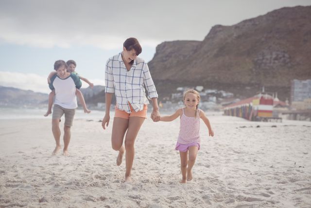 Happy family running on sand at beach