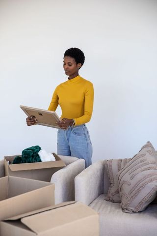 Woman Unpacking Moving Boxes in Modern Living Room