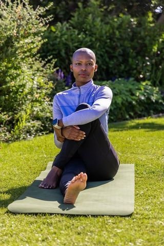 Serene outdoor yoga mindful stretching by athlete on mat wearing smartwatch and activewear
