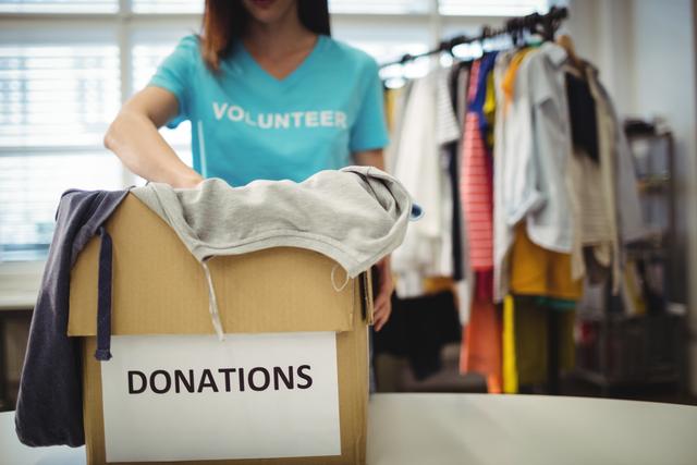 Female Volunteer Sorting Clothes in Donation Box - Download Free Stock Photos Pikwizard.com