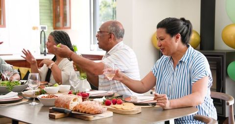 Senior Friends Celebrating with Toast at Home Dinner