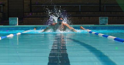 Male Swimmer Performing Breaststroke in Outdoor Pool