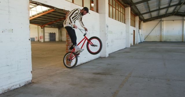 Young Man Performing BMX Tricks in Abandoned Warehouse - Download Free Stock Images Pikwizard.com