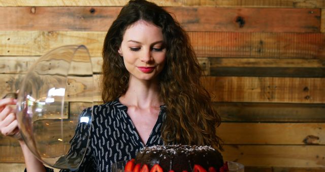 Young Woman Unveiling Strawberry Chocolate Cake in Rustic Kitchen - Download Free Stock Images Pikwizard.com