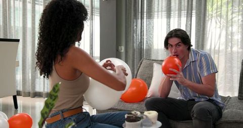 Couple Preparing Birthday Party with Balloons in Living Room