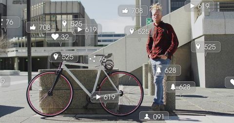 Leaning urban cyclist with fixed-gear bike and floating social media icons at sunlit plaza