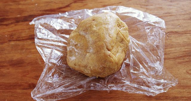 Close-Up of Cookie Dough on Plastic Wrap on Wooden Table - Download Free Stock Images Pikwizard.com