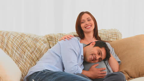 Expecting Couple Enjoying Tender Moment on Cozy Couch