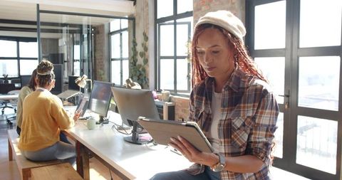 Female Professionals Collaborating in Urban Loft Office