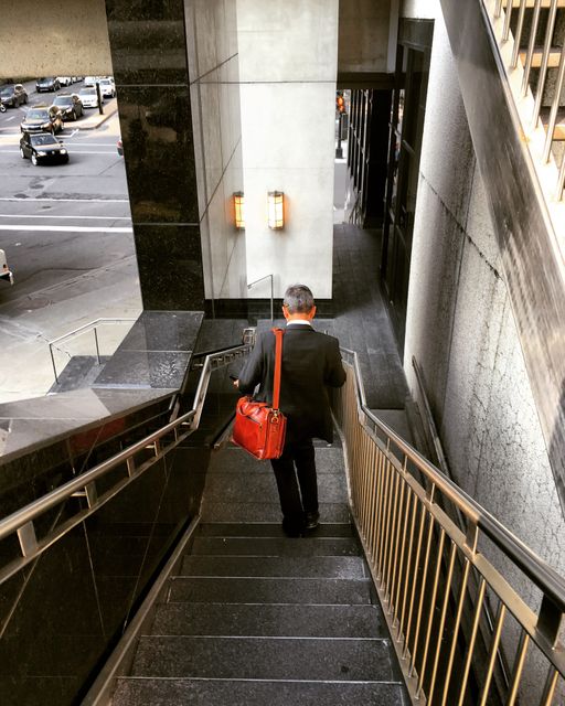 Businessman Carrying Red Bag Walking Down Stairs in Modern Office Building - Download Free Stock Images Pikwizard.com