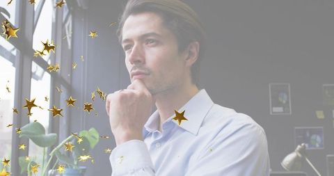 Pensive Businessman Looking Out Office Window with Golden Stars Overlay
