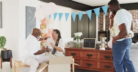 Happy family opening balloons at baby shower celebration
