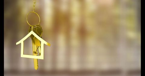 Golden house shaped keyring on gold chain suggesting luxury