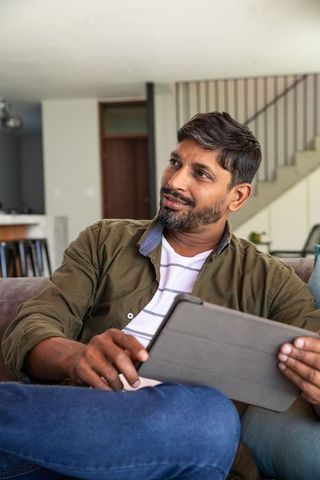 Man relaxing with tablet in minimalist contemporary living room