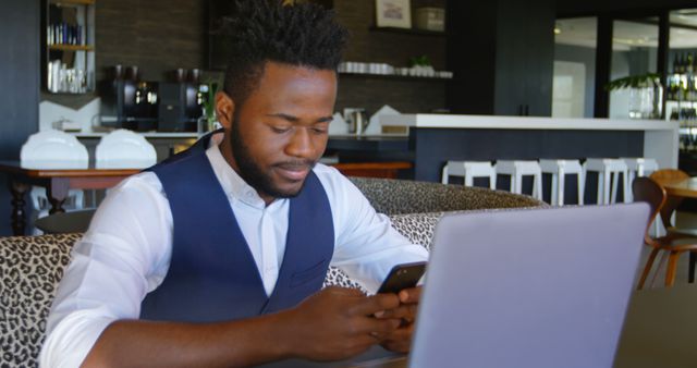 Young Businessman Working on Laptop and Smartphone in Modern Cafe - Download Free Stock Images Pikwizard.com