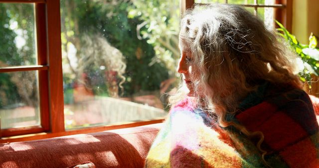 Woman Wrapped in Blanket Sitting by Window on Sunny Day - Download Free Stock Images Pikwizard.com