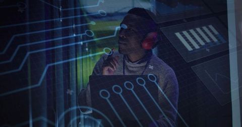 Technician adjusting holographic circuit on tablet at low-light control console