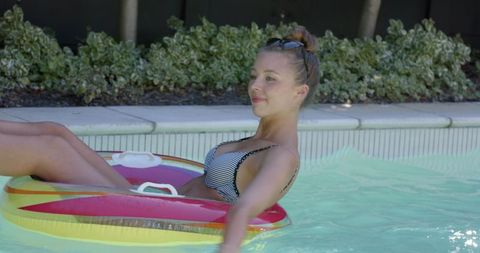 Woman Relaxing in Backyard Pool on Inflatable Ring