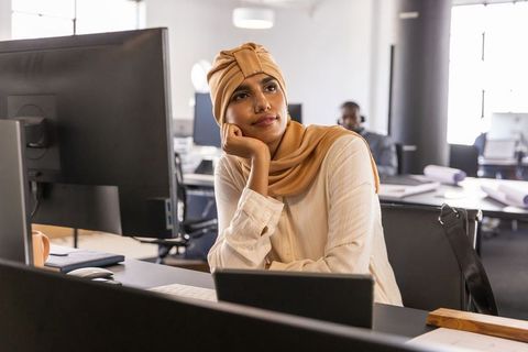 Thoughtful businesswoman in headscarf contemplating over work in office