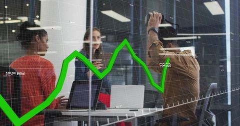 Business team discussing financials with green stock graph overlay in glass meeting room