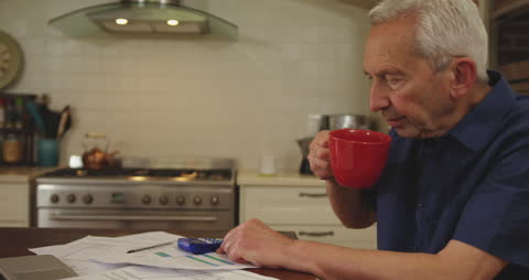 Senior Man Enjoying Coffee and Newspaper at Home