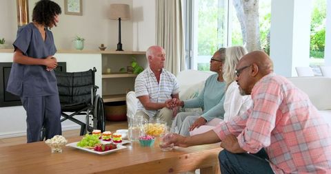 Senior Friends Enjoying Refreshments and Spending Quality Time Indoors