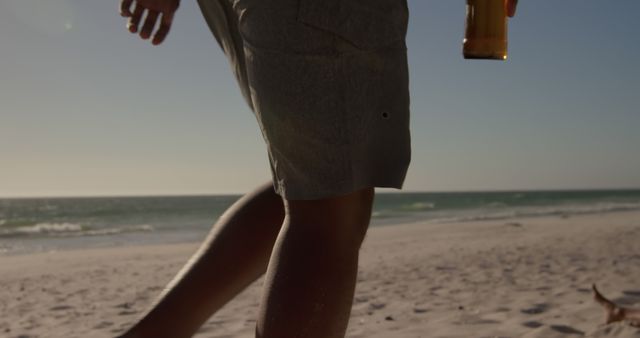 Person Enjoying Walk on Beach Holding Drink - Download Free Stock Images Pikwizard.com