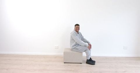 Man Relaxing in Modern Minimalist Room Wearing Casual Tracksuit - Download Free Stock Images Pikwizard.com
