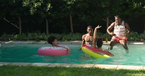Young Friends Enjoying Day at Pool with Inflatable Donut Floats