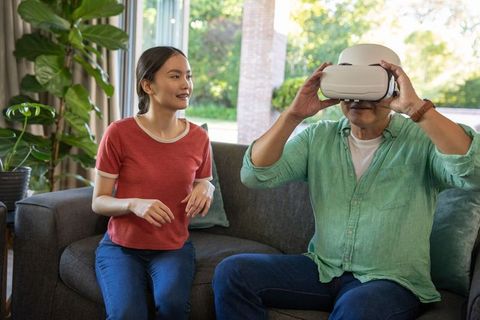 Father and daughter experimenting with virtual reality at home