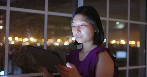 Businesswoman Working Late Night in Office with Tablet