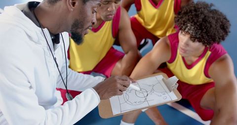 Basketball coach explaining strategy to players during training session