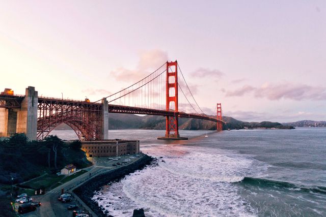 Golden Gate Bridge standing majestically over calm ocean water during a beautiful sunset. Famous landmark perfect for travel and tourism marketing materials, postcards, brochures, and website backgrounds capturing the essence of San Francisco.