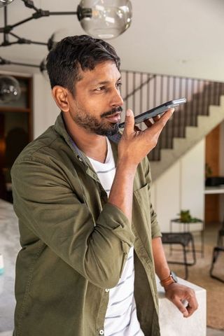 South Asian Man in Modern Home Using Voice Assistant Technology