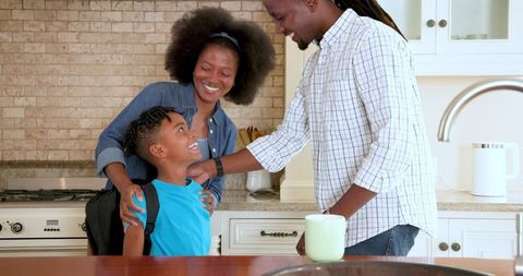 Parents and Son Smiling in Kitchen Before School Day