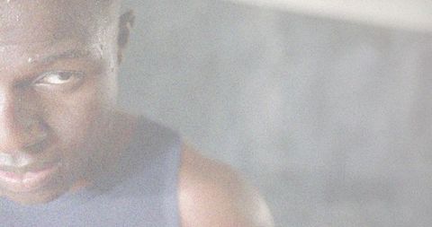 Gazing male tilting head in sleeveless top, grainy monochrome closeup with copy space