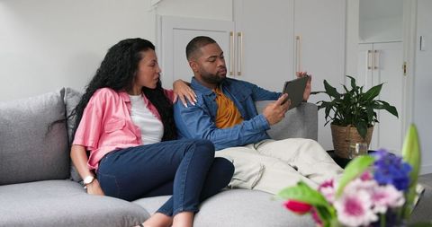 Young Couple Sharing Joyful Pregnancy News via Tablet