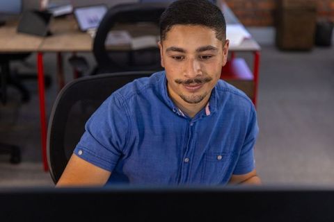 Focused Professional Typing in Modern Office Setting