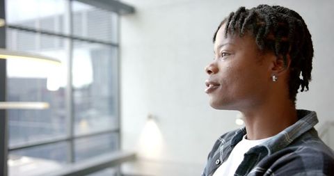Contemplative Moment in Modern Office Setting with Large Window View