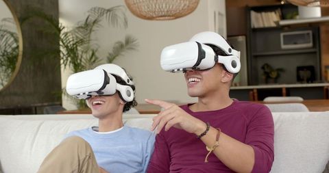 Male Friends Enjoying Virtual Reality in Living Room